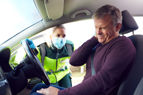 Female Paramedic Helping Mature Male Driver With Whiplash Injury